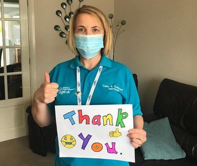 Nurse holding thank you sign wearing mask